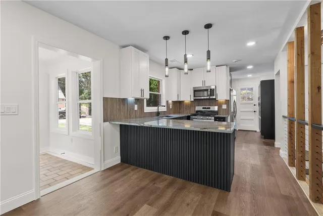 a kitchen with stainless steel appliances granite countertop a refrigerator and a stove top oven