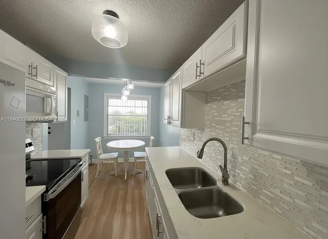 a kitchen with a sink stainless steel appliances and cabinets