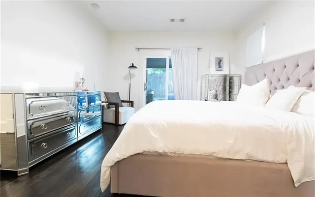 a spacious bedroom with a bed and a view of kitchen