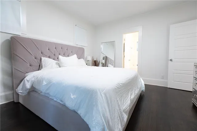 a large bed sitting in a bedroom next to a window