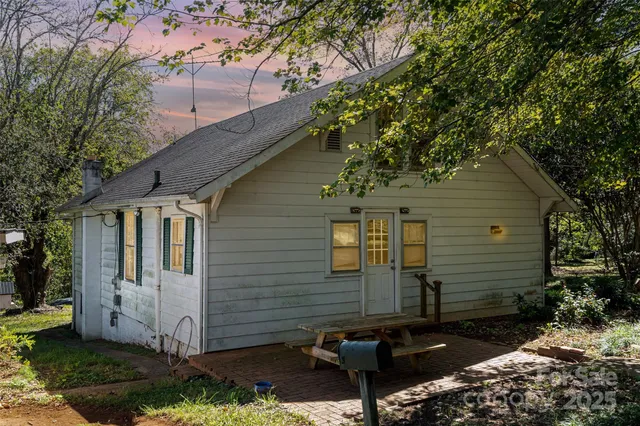 a view of a small house with a yard