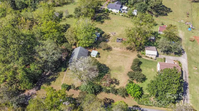 an aerial view of residential house with outdoor space and trees all around