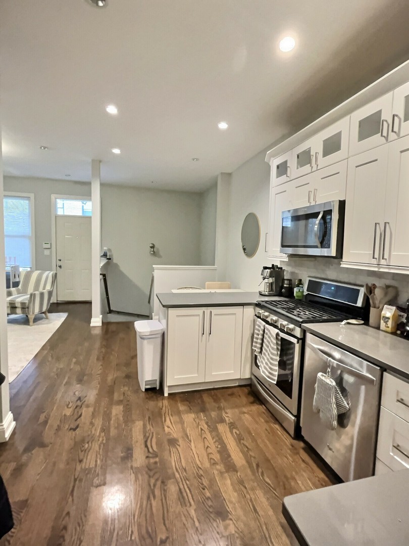 2538 North Southport Avenue, Unit 1R Chicago, IL 60614 - Photo 7 of 12 a kitchen with a stove a sink and a microwave