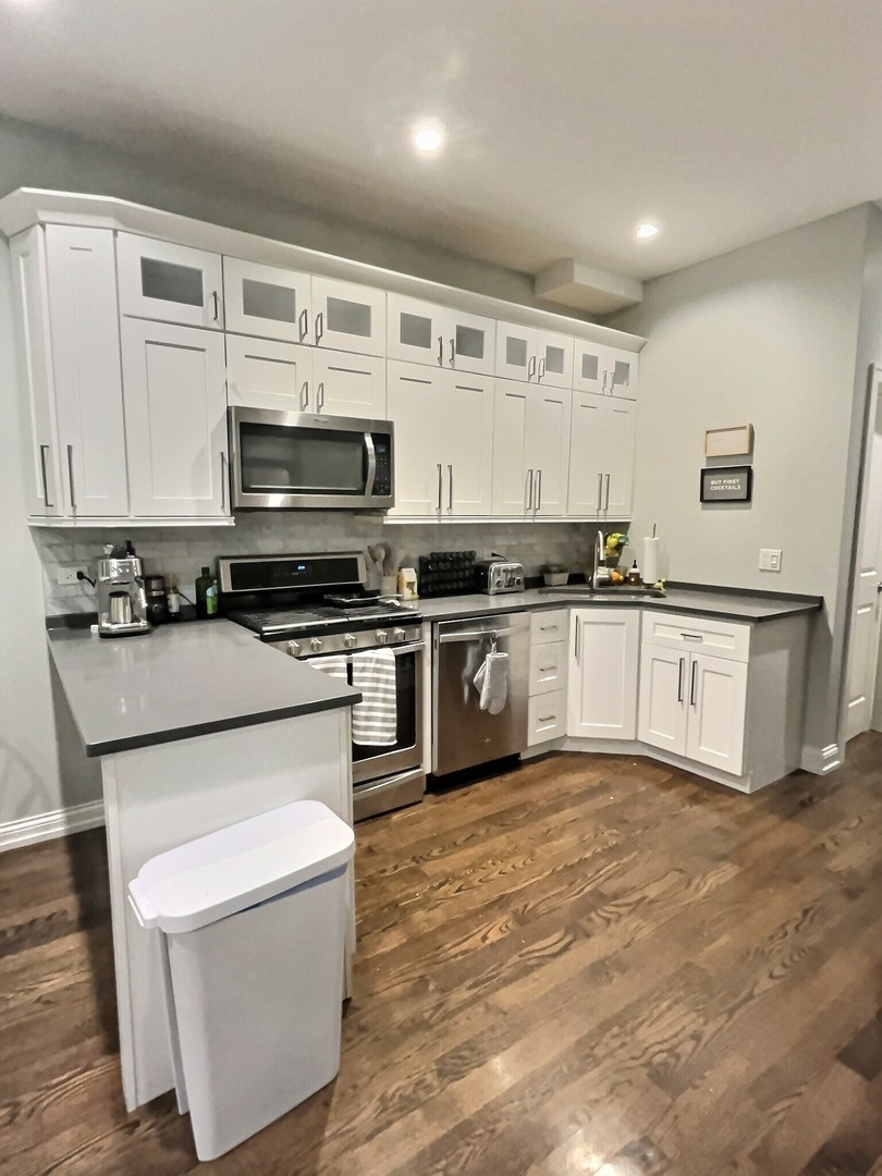 2538 North Southport Avenue, Unit 1R Chicago, IL 60614 - Photo 9 of 12 a kitchen with stainless steel appliances a stove a sink and a microwave