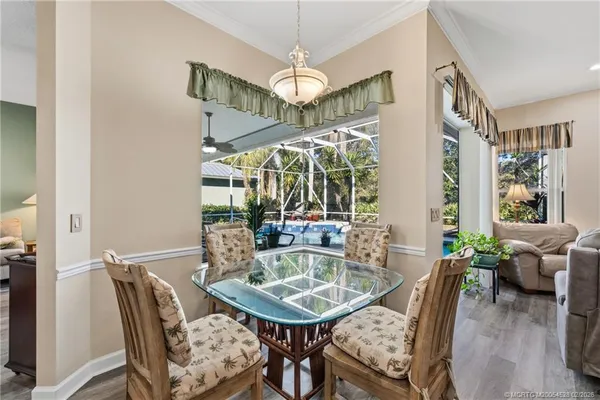 a dining room with furniture a chandelier and wooden floor