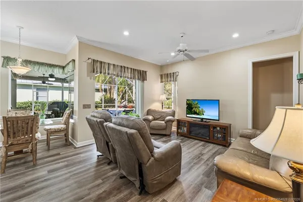 a living room with furniture a flat screen tv and a large window