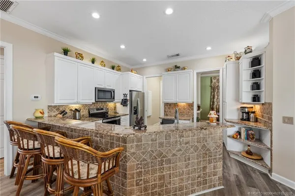 a kitchen with stainless steel appliances kitchen island granite countertop a sink and cabinets