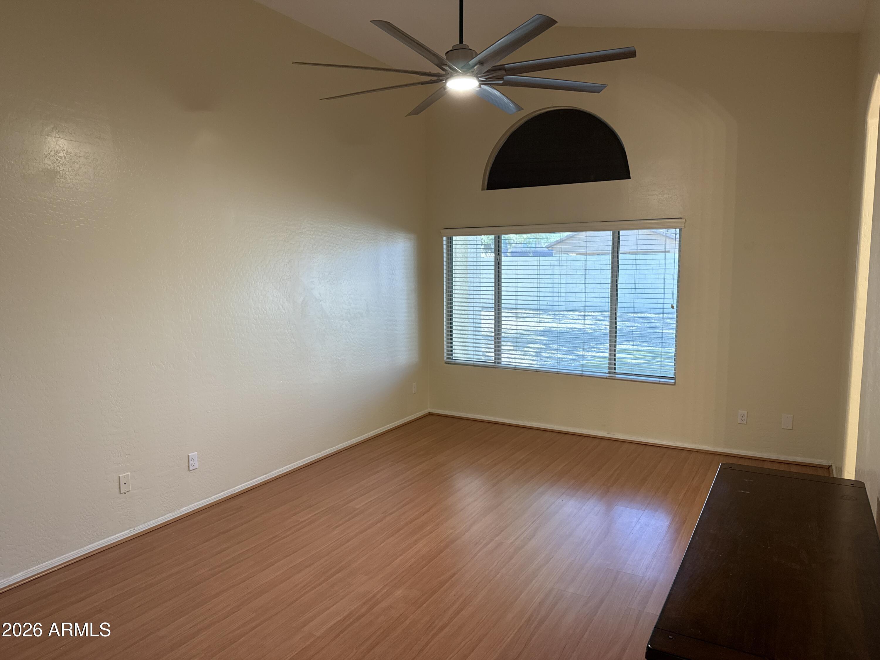 9630 West Reno View Drive Peoria, AZ 85345 - Photo 7 of 21 an empty room with wooden floor chandelier fan and windows