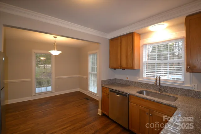 a kitchen with granite countertop a sink and a wooden floor