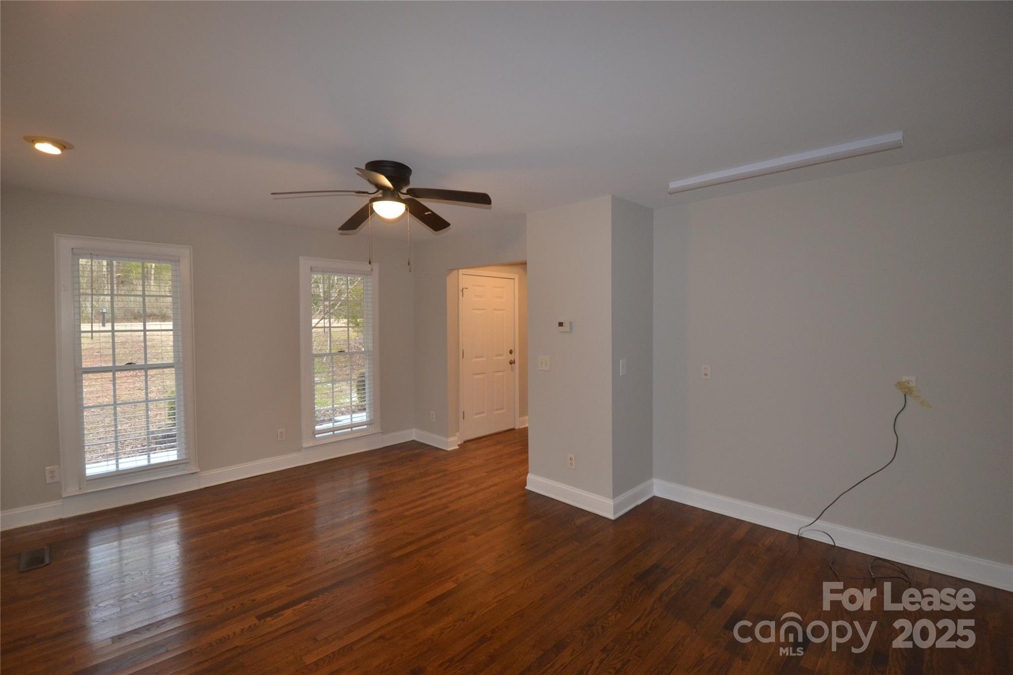 9024 McElroy Road Waxhaw, NC 28173 - Photo 5 of 43 an empty room with wooden floor and windows