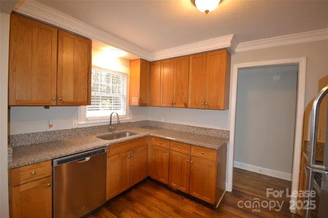 a kitchen with a sink cabinets appliances and a window