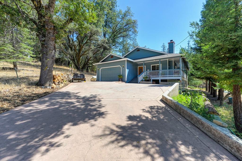 a front view of a house with a yard covered with trees