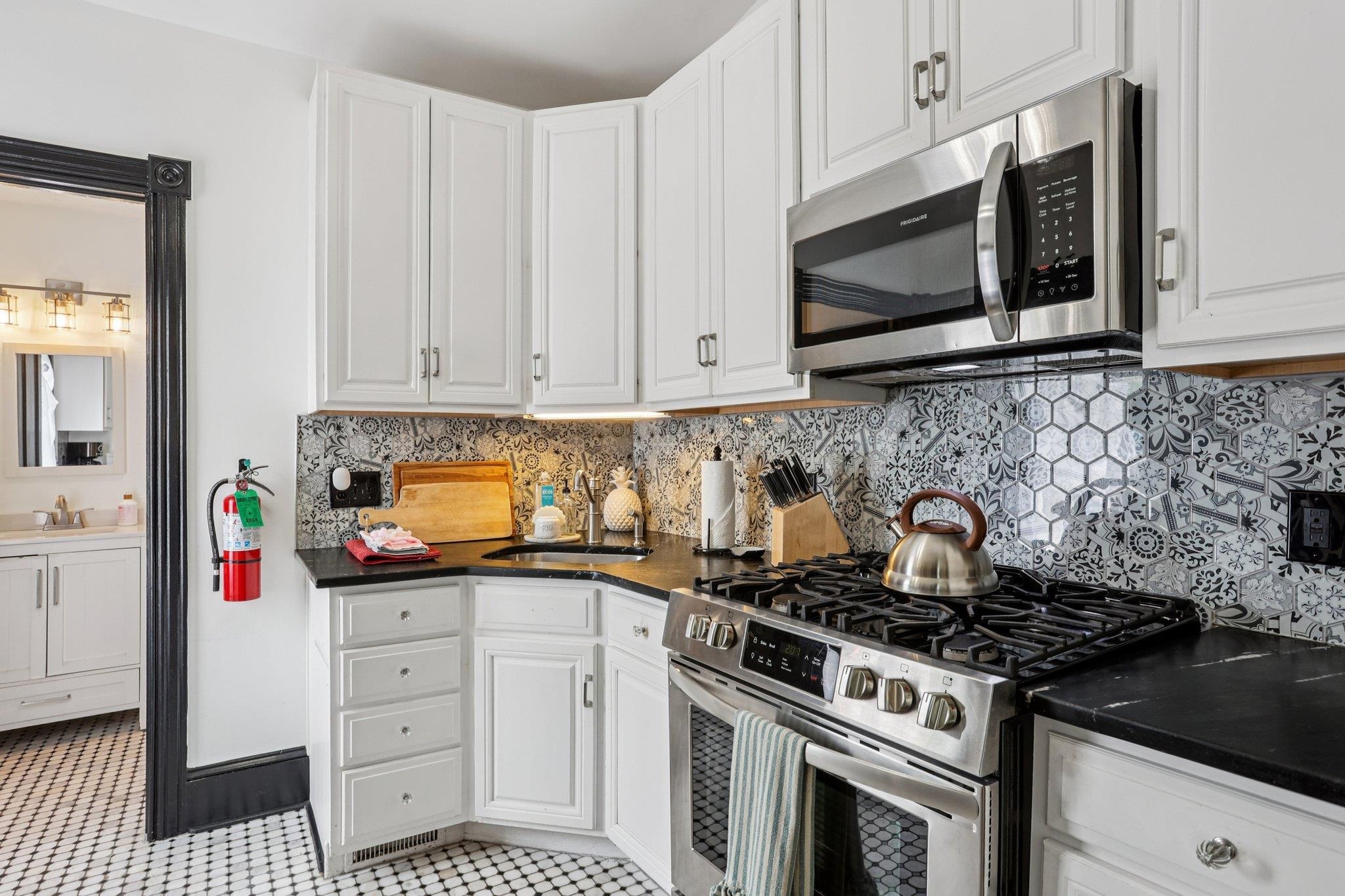 414 Broadway, Unit 414 West Cape May, NJ 08204 - Photo 35 of 48 a kitchen with stainless steel appliances a stove a microwave and cabinets