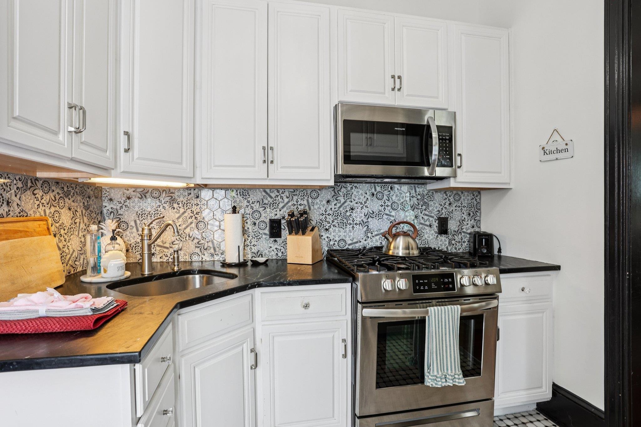 414 Broadway, Unit 414 West Cape May, NJ 08204 - Photo 37 of 48 a kitchen with stainless steel appliances wooden cabinets and a stove top oven