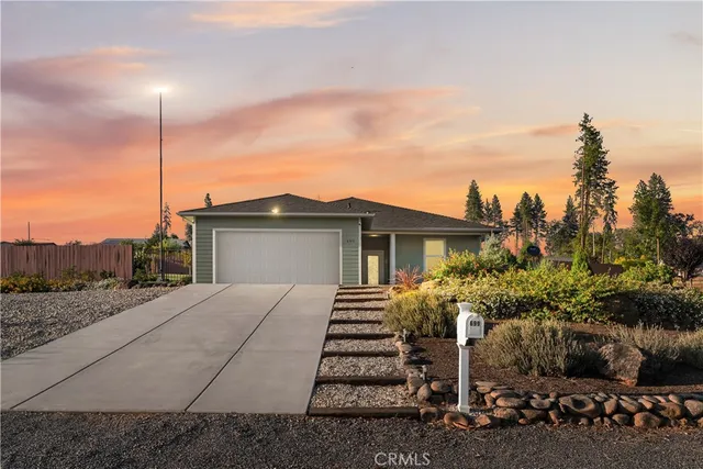 a view of a house with a yard and potted plants