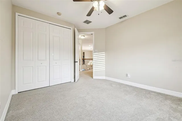 a sign that is sitting on a brick wall with plants and large trees