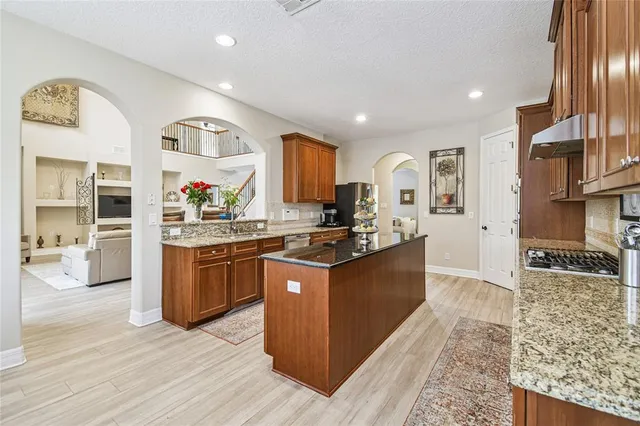 a kitchen with stainless steel appliances granite countertop a sink stove and cabinets