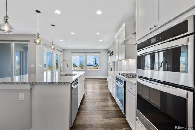 a kitchen with stainless steel appliances granite countertop lots of counter top space and wooden floor