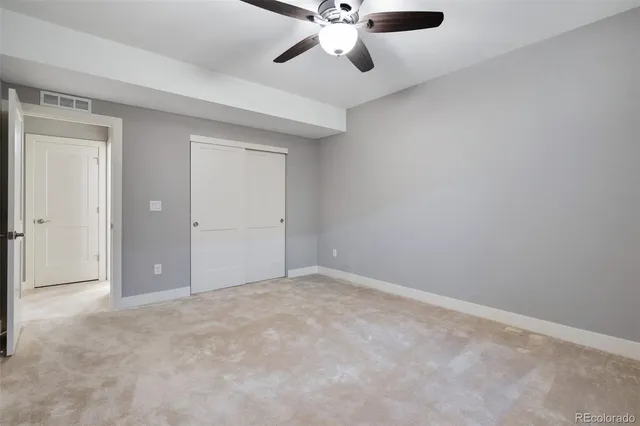a view of an empty room and chandelier fan
