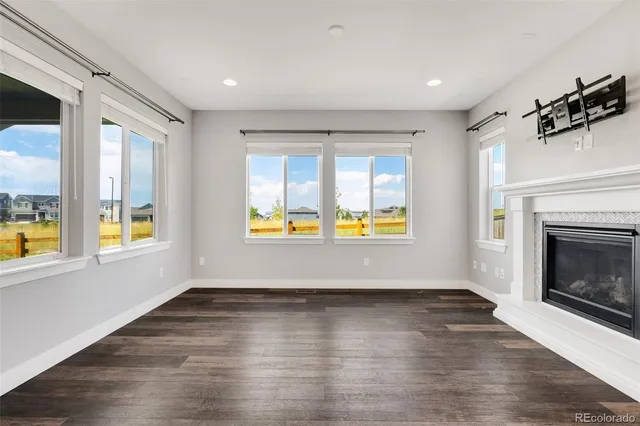 an empty room with windows and fireplace