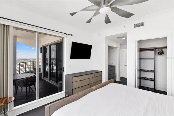 a bedroom with a bed and a flat tv screen on dresser