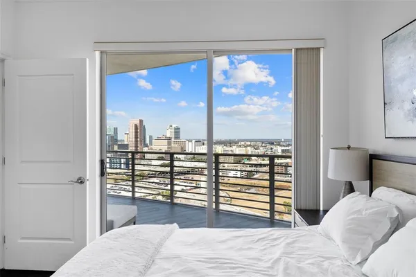 a bedroom with a large window and a balcony