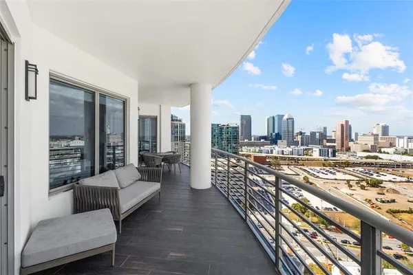 a balcony with furniture and a view of city