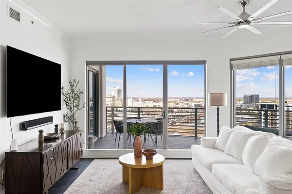 a living room with furniture a flat screen tv and a large window