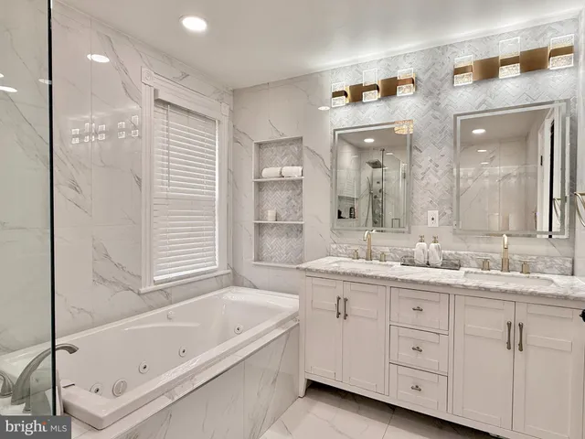a bathroom with a granite countertop sink mirror bathtub and next