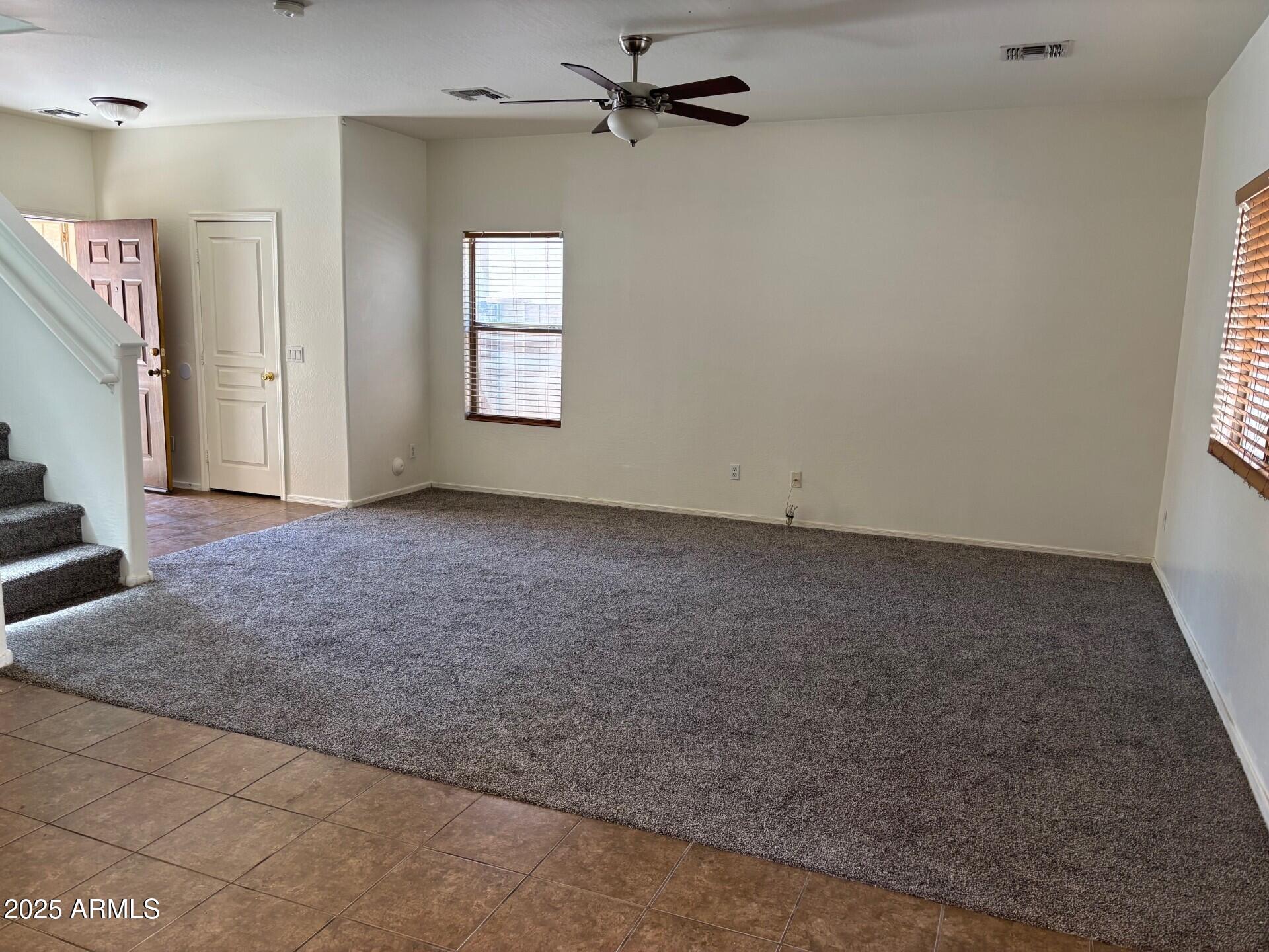 7014 West Mercer Lane Peoria, AZ 85345 - Photo 2 of 14 an empty room with windows and fan