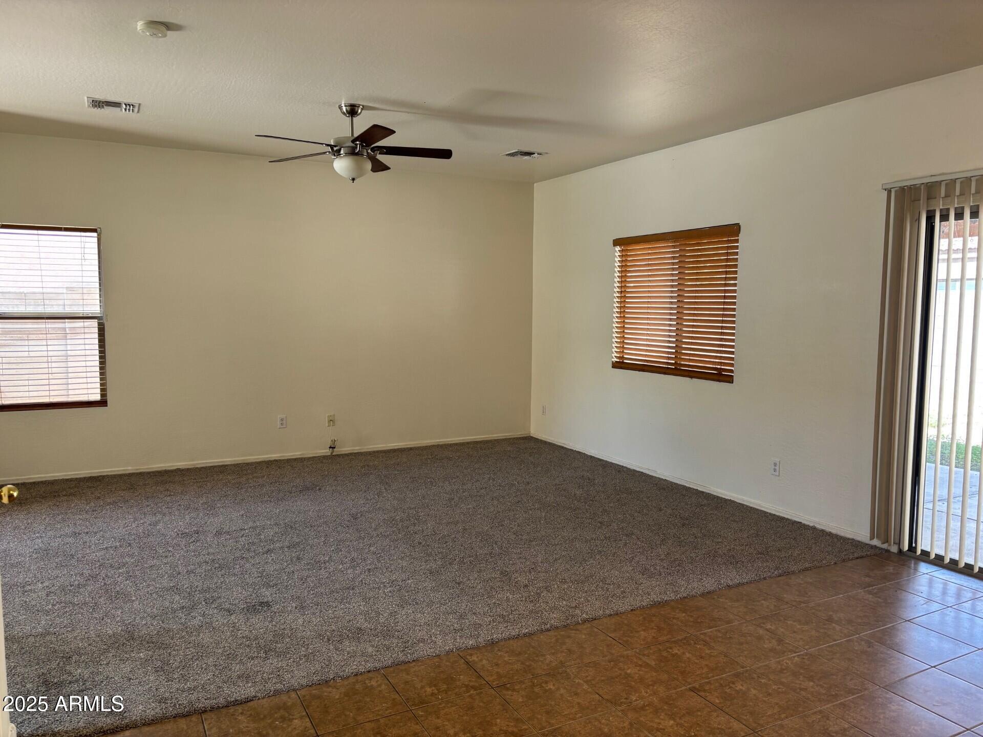 7014 West Mercer Lane Peoria, AZ 85345 - Photo 4 of 14 wooden floor in an empty room with a window