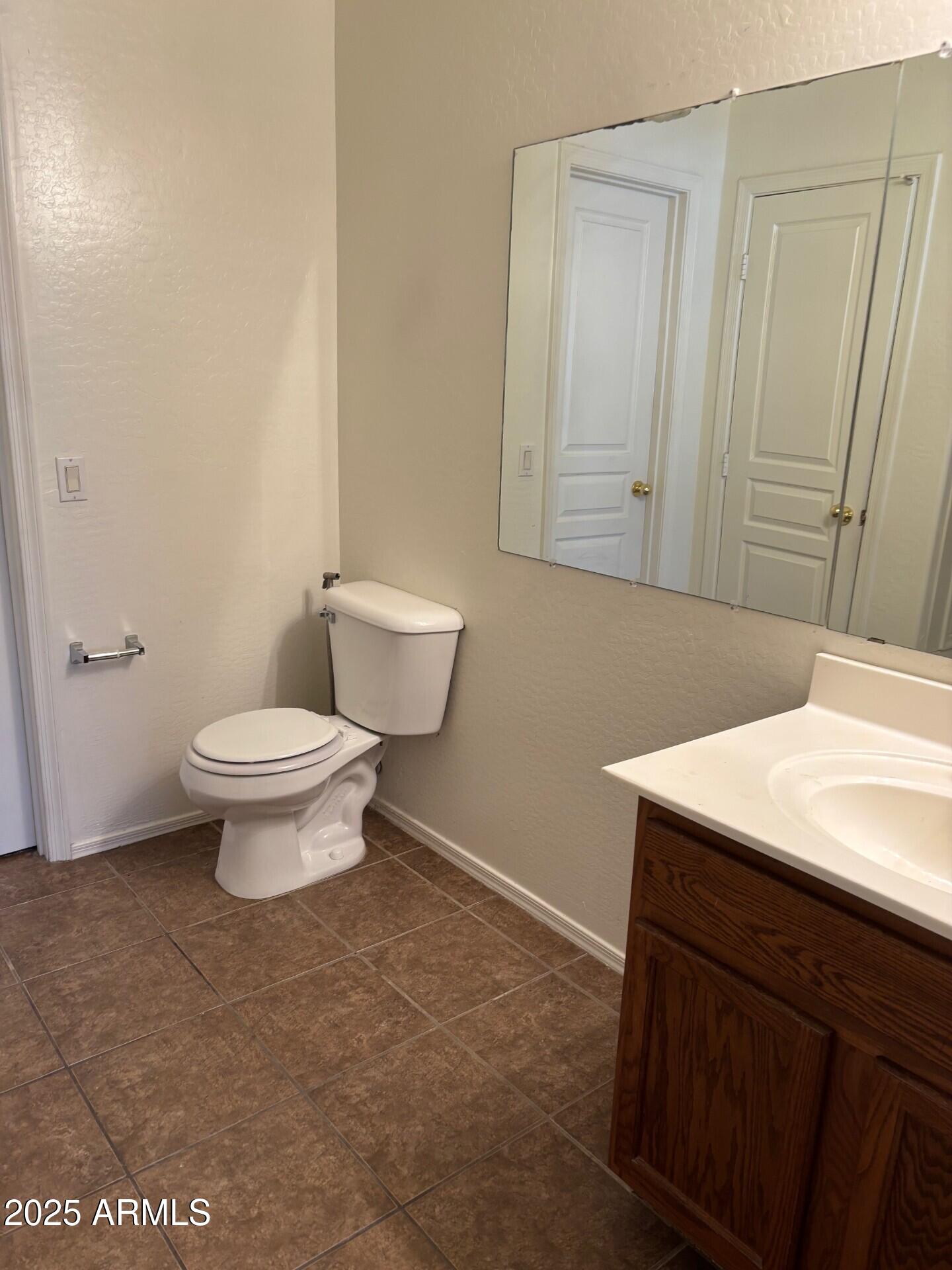 7014 West Mercer Lane Peoria, AZ 85345 - Photo 5 of 14 a bathroom with a sink a toilet and mirror