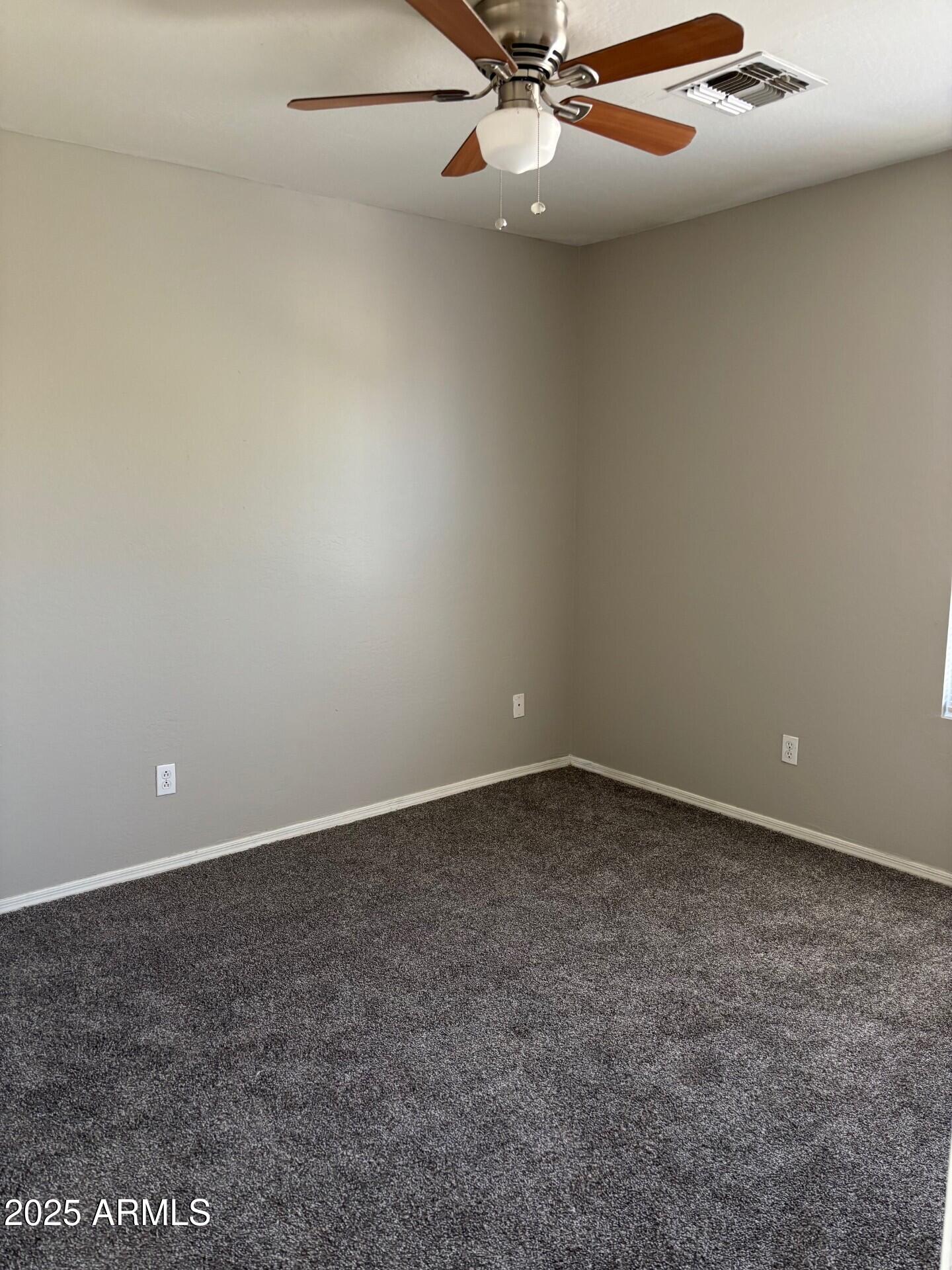 7014 West Mercer Lane Peoria, AZ 85345 - Photo 7 of 14 an empty room with a ceiling fan and carpet