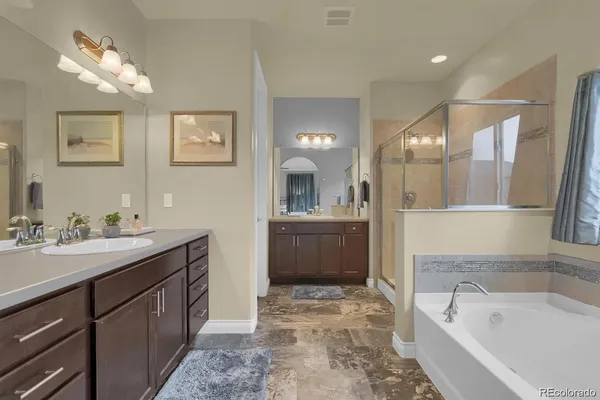 a spacious bathroom with a tub sink and mirror