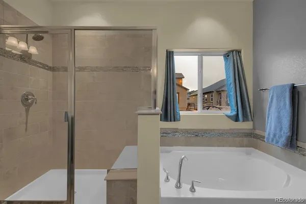 a bathroom with a granite countertop bathtub shower and mirror