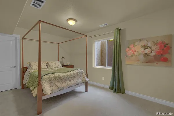 a bedroom with a bed and a painting on the wall