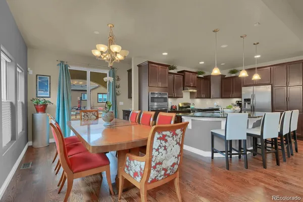 a view of a dining room with furniture wooden floor and chandelier