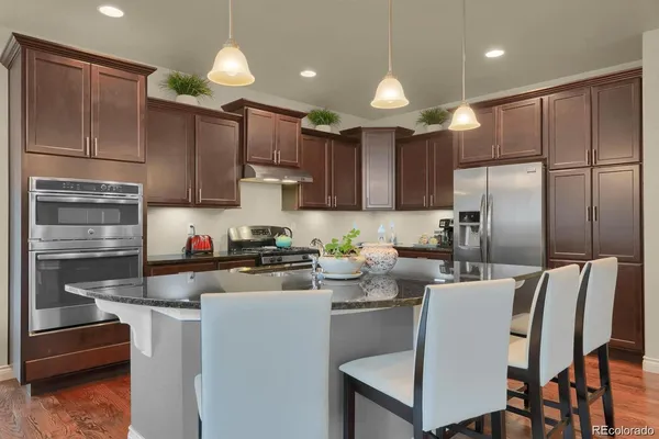 a kitchen with a refrigerator a stove a sink and cabinets