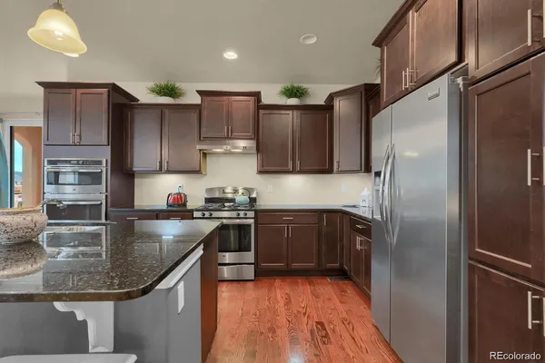 a kitchen with stainless steel appliances granite countertop a refrigerator a sink and a stove