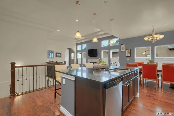 a kitchen with stainless steel appliances granite countertop a stove a sink a dining table and chairs