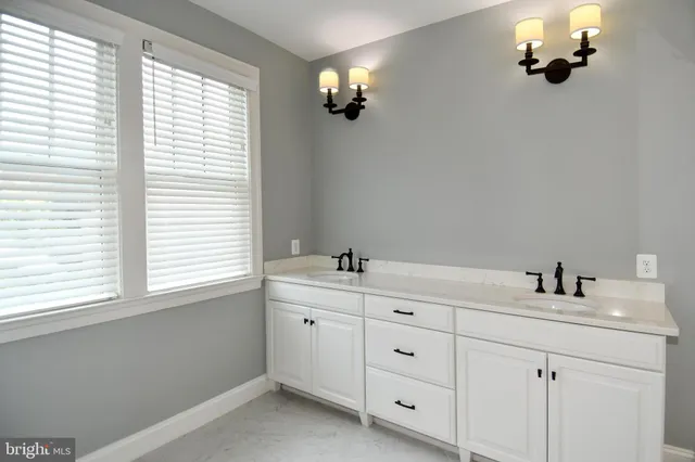 a bathroom with a granite countertop sink a mirror and shower