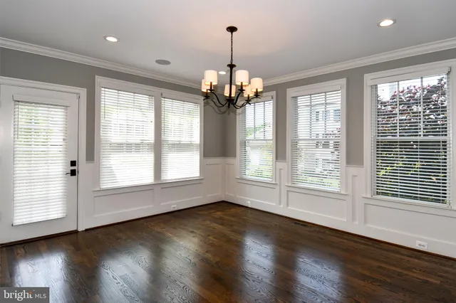 a view of an empty room and chandelier fan