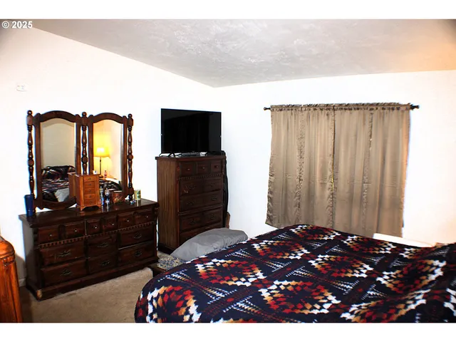 a bedroom with a bed and a television