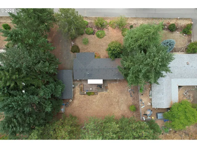 a backyard of a house with table and chairs under an umbrella