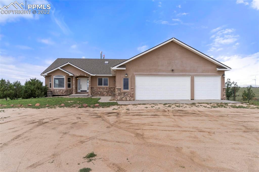30103 Washington Road Calhan, CO 80808 - Photo 3 of 48 a front view of a house with a yard and garage