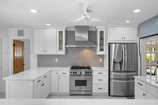 a kitchen with cabinets stainless steel appliances and wooden floor