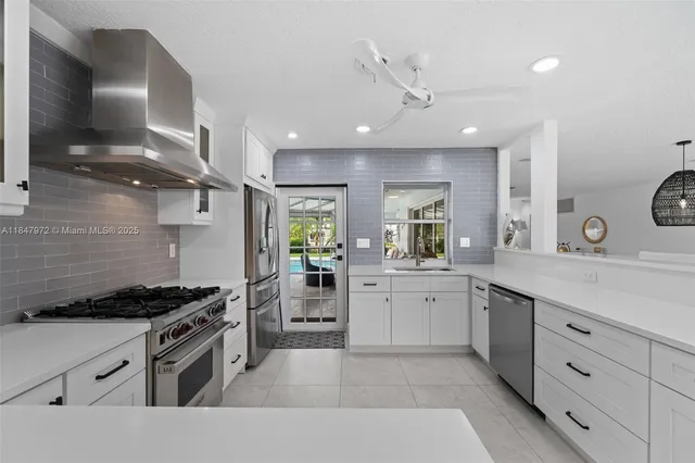 a kitchen with stainless steel appliances a sink stove and cabinets