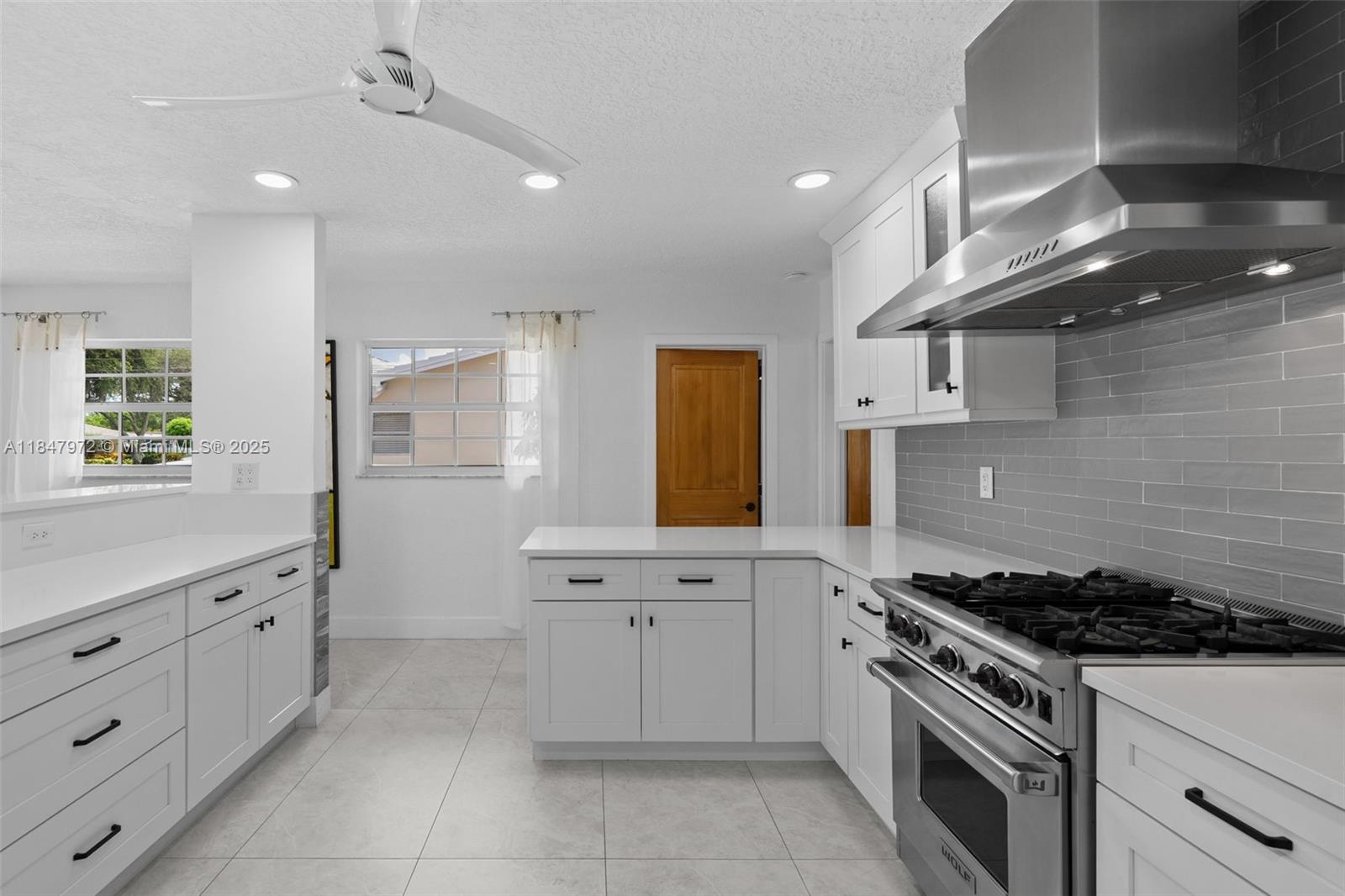 2681 Northeast 9th Court Pompano Beach, FL 33062 - Photo 19 of 58 a kitchen with granite countertop a stove sink and cabinets