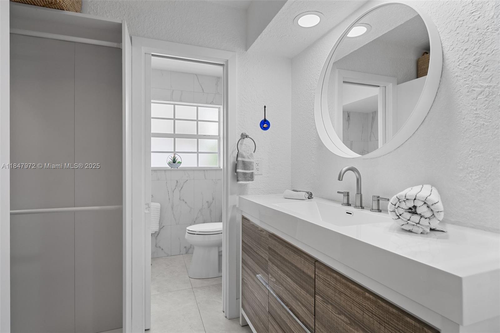 2681 Northeast 9th Court Pompano Beach, FL 33062 - Photo 25 of 58 a bathroom with a sink a toilet and a mirror