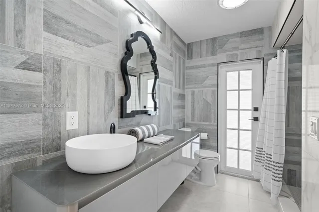 a en suite bathroom with a granite countertop vanity and mirror